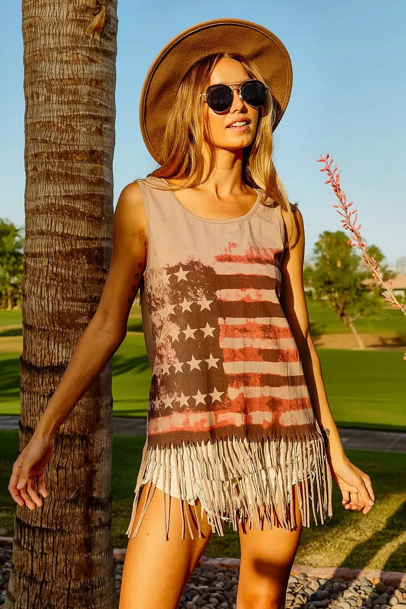 American flag fringe tank top for women worn outdoors, featuring vintage American flag graphic and trendy fringe hem.
